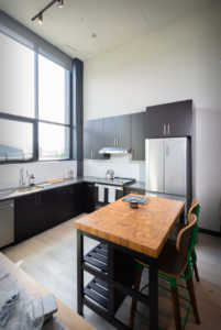 Kitchen area in the apartments showing island, cabinets and countertops.