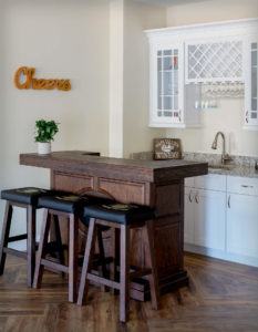 Game Room bar area at Regency Village in Merrimac, MA,with CNC Elegante White Cabinets, featuring glass doors and custom double-height moulding.