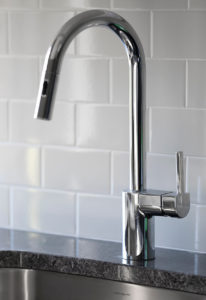 Countertop detail with tile backsplash and stainless steel sink at The Borden Luxury Apartments.