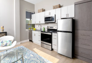 Studio unit kitchens feature Urbana cabinets in Putty Texture Laminate and Steel Grey Granite counters at The Borden Luxury Apartments in Wethersfield, CT.