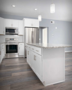 Front of island CNC Luxor cabinets in White in the kitchens at Residences On Main in Bristol.